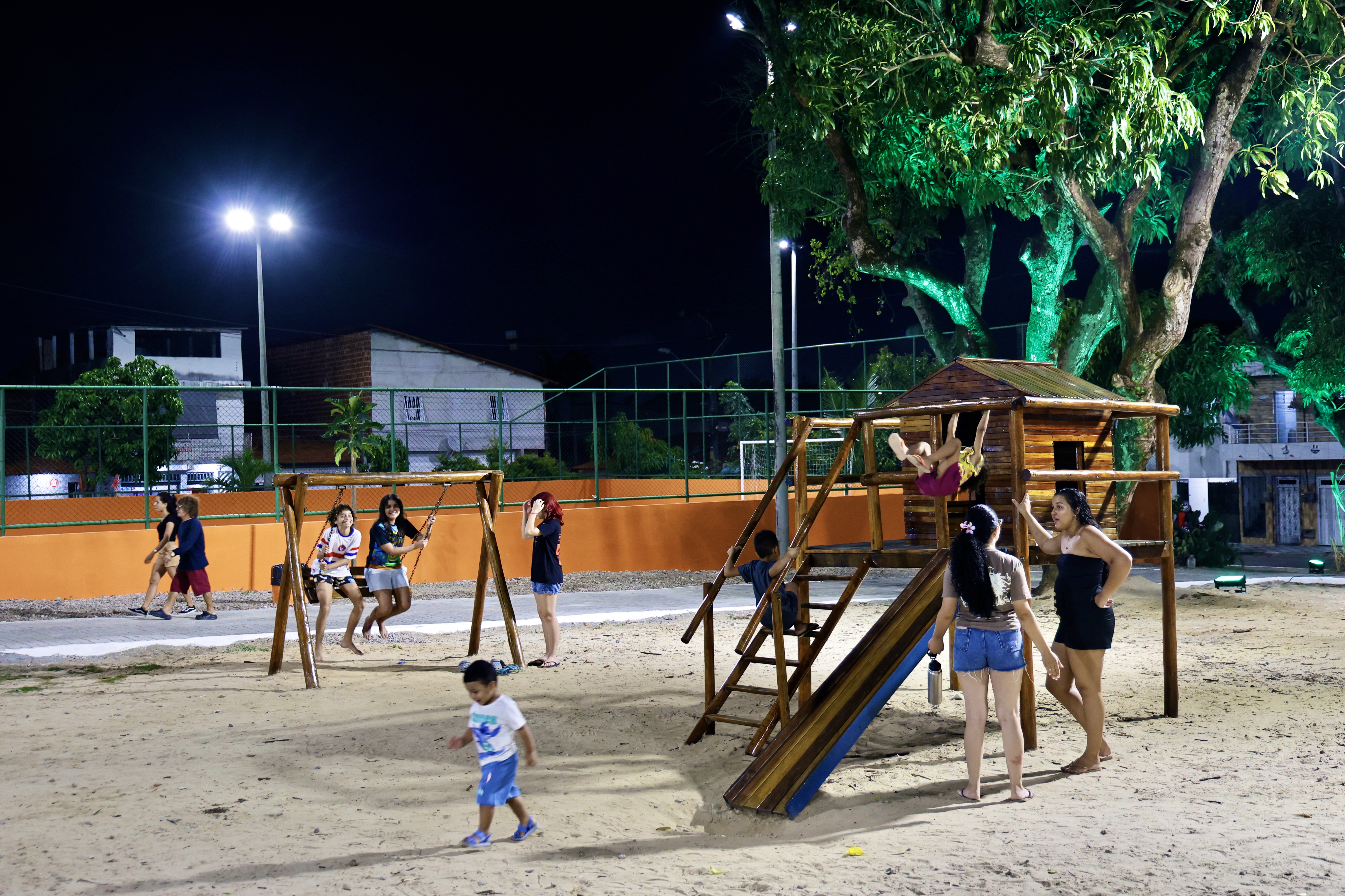 Crianças brincando nos brinquedos do parquinho da Praça